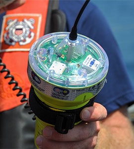 Close up view of a sailor inspecting an EPIRB